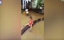 Bé trai Thanh Hóa cưỡi trăn trong mưa ngập lên báo Anh