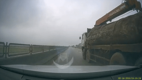 Video: Xe cẩu chở gỗ lấn làn, ép gẫy gương ô tô con rồi bỏ chạy