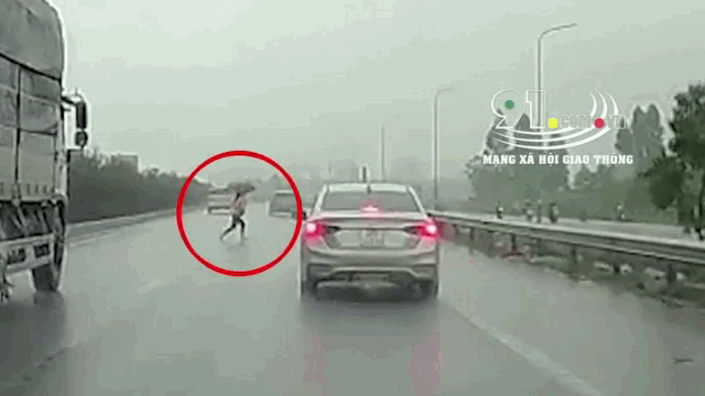 Video: Cầm ô băng qua đường cao tốc, nữ công nhân bị ô tô tông văng