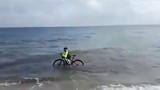 Người đạp xe chạy xuống biển để tránh bị cảnh sát phạt 
